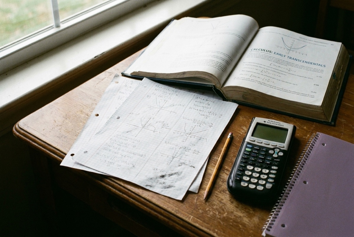 Graph paper with pencil-worked algebra and calculus problems, the foundational math skills Lily’s Tutoring Services rebuilds with Maryland students
